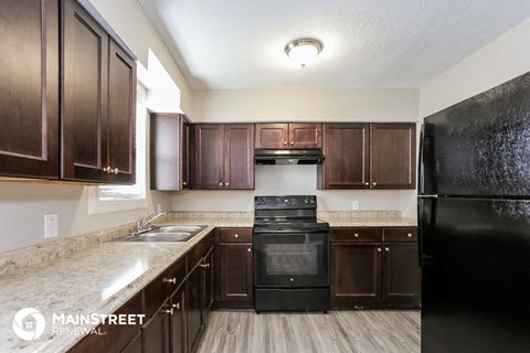 a kitchen with dark wood cabinets and black appliances