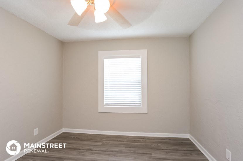 the interior of a room with a window and a ceiling fan