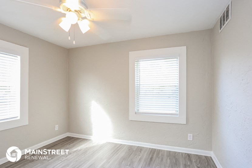 a bedroom with a ceiling fan and a window
