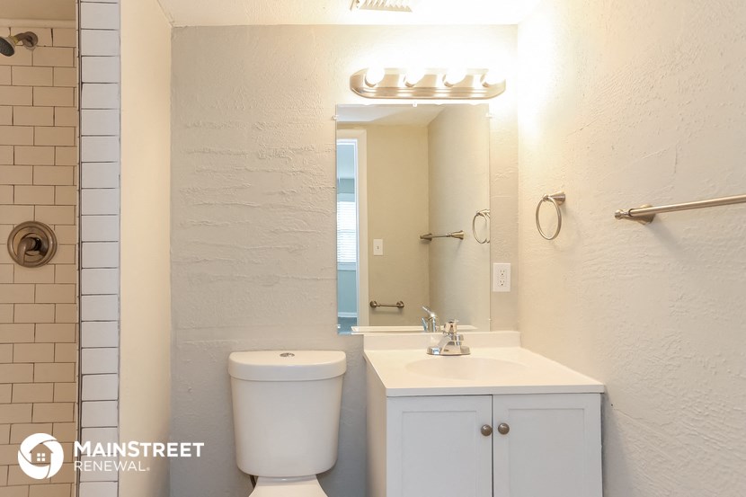 a bathroom with a toilet and a sink and a mirror