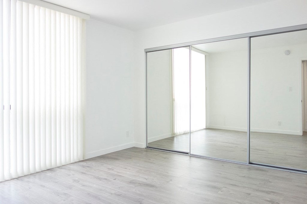 an empty room with white walls and sliding glass doors