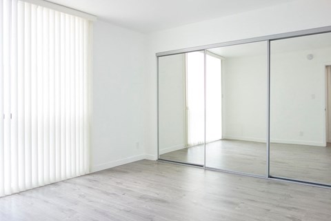 an empty room with white walls and sliding glass doors