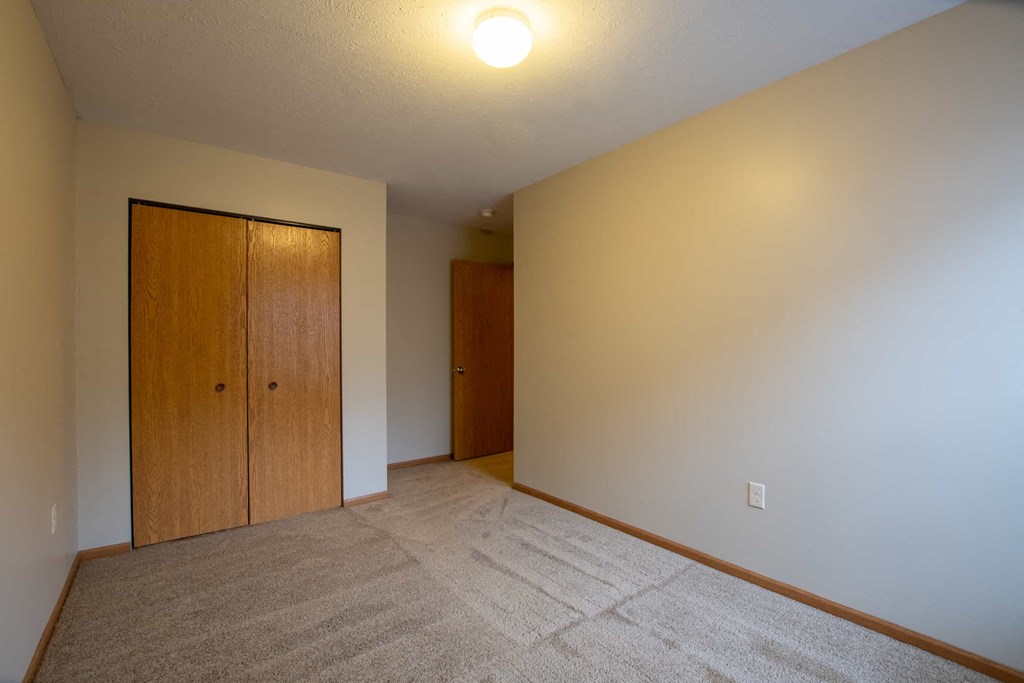 a room with a carpeted floor and a closet