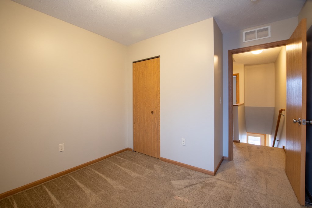 a room with a carpeted floor and a door to a hallway