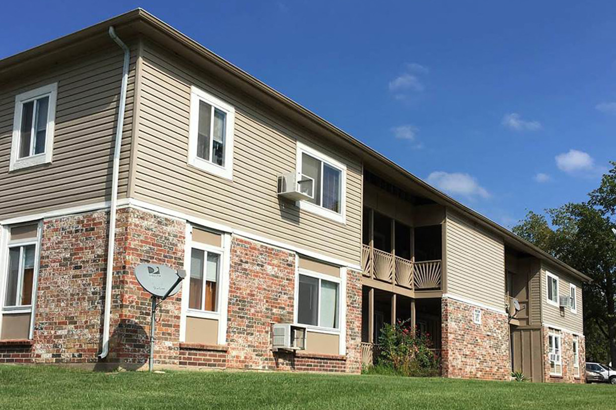 A brick building with a satellite dish on the left side.