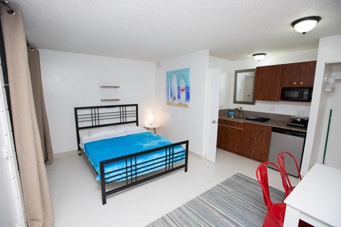 A bedroom with a bed, desk, and chair.
