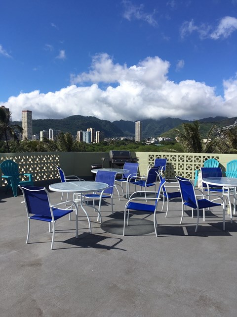 A table with blue chairs is set up on a patio.