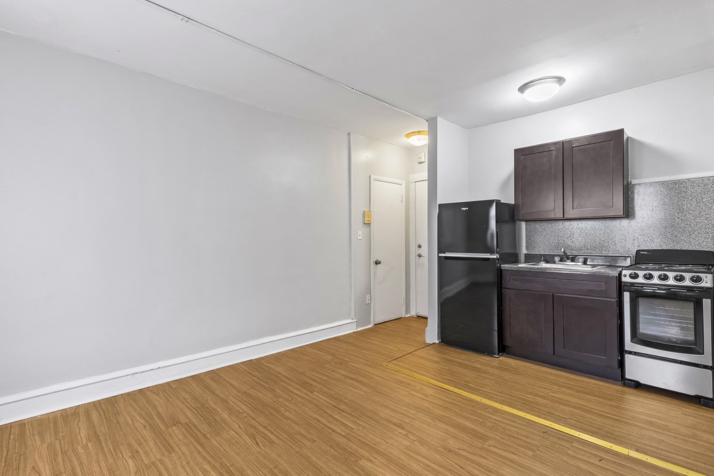 the living room of an apartment with a stove and refrigerator
