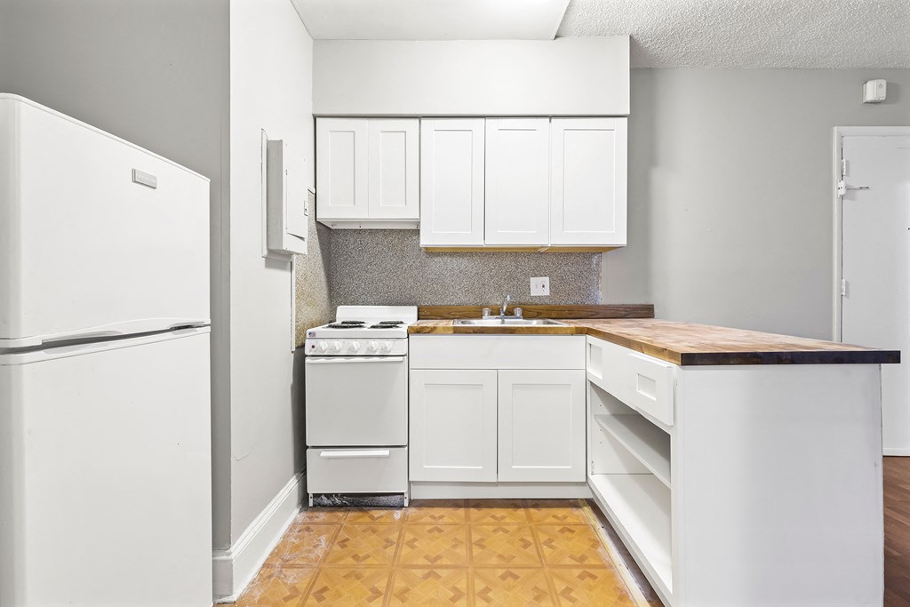 a white kitchen with white appliances and white cabinets