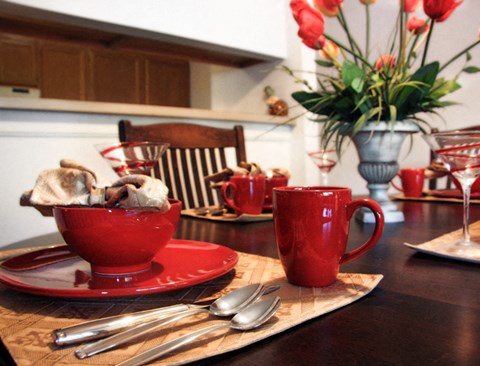 a kitchen table with a cup of tea and a bowl of cookies