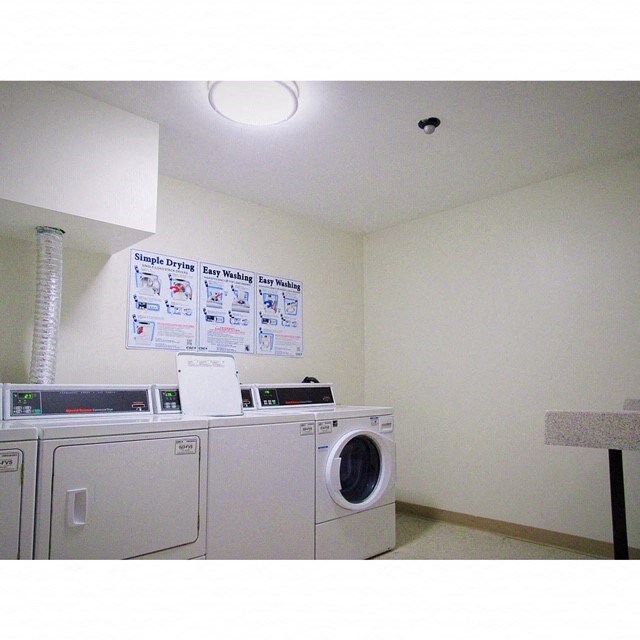 a laundry room with a washing machine and a sign on the wall
