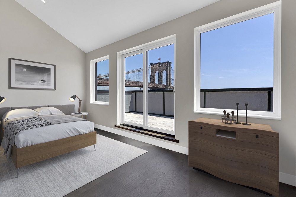 A bedroom with a large bed and a view of a bridge through the windows.