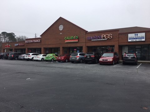 a parking lot full of cars in front of a store