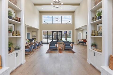 A spacious living room with a large window, a sofa set, and a coffee table.