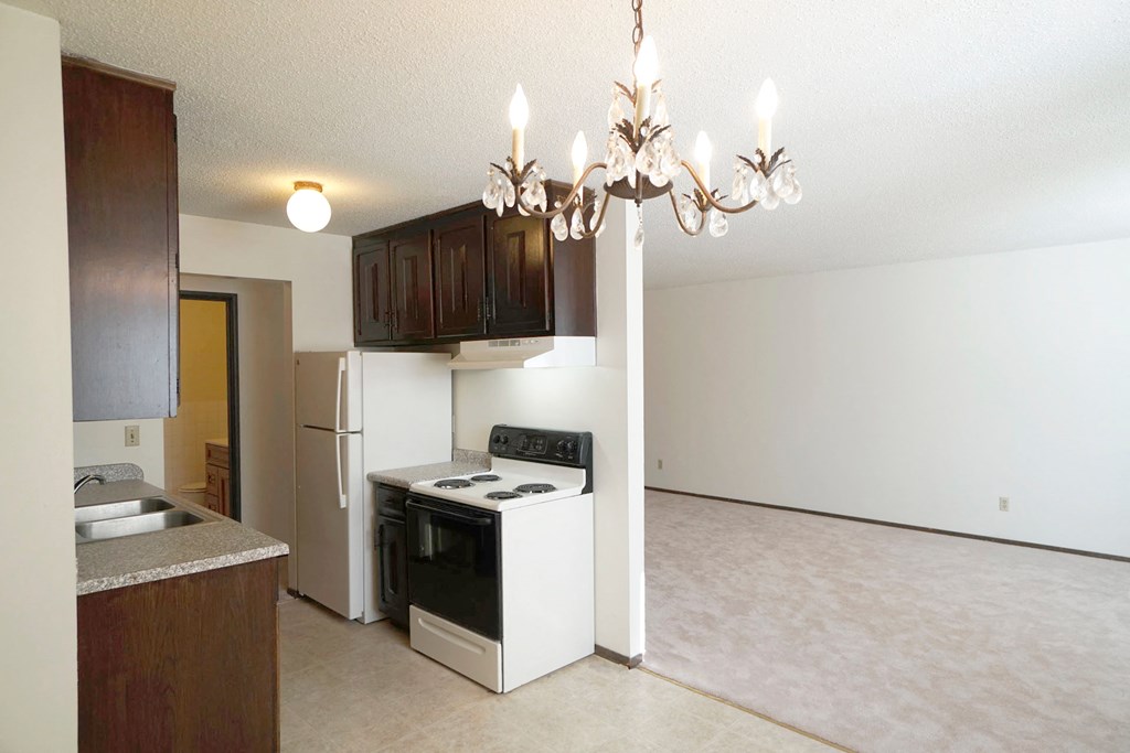 Arlington Place Kitchen on the left with appliances such as a stove and fridge and an empty space showing part of the livingroom