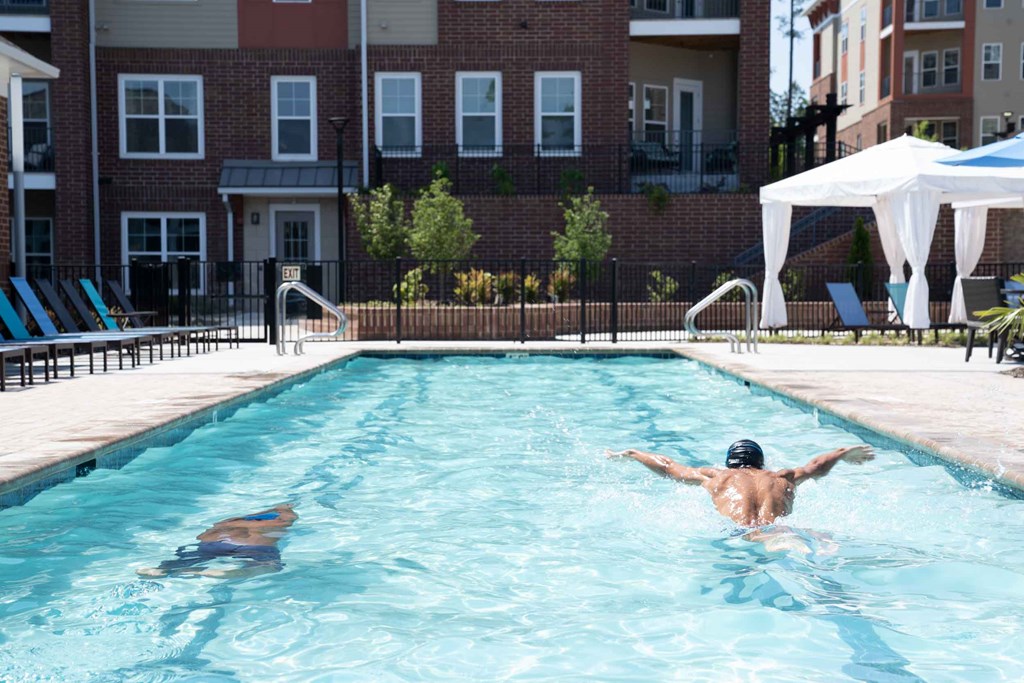 a couple of people swimming in a swimming pool