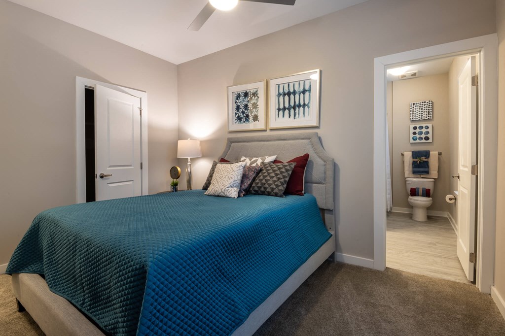 A Bedroom With a Blue Bedspread at The Aster Apartments, North Carolina, 27519