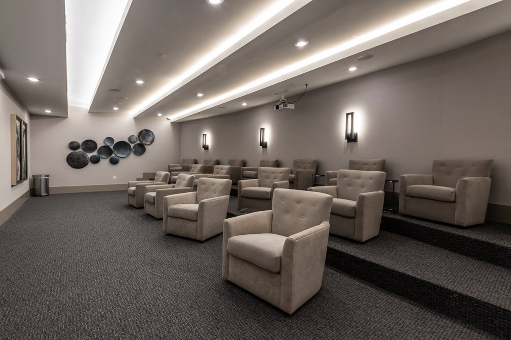 a large room with a projector screen and chairs in it