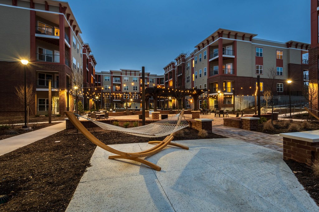 a hammock in the middle of an apartment complex at night