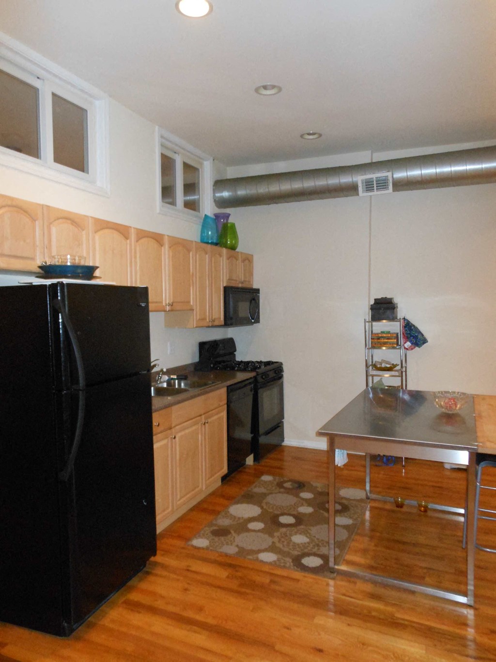 a kitchen with a black refrigerator and a table