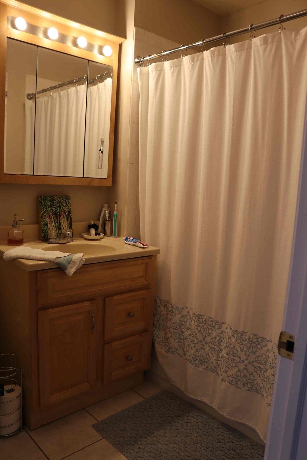 a bathroom with a shower and a sink and a mirror