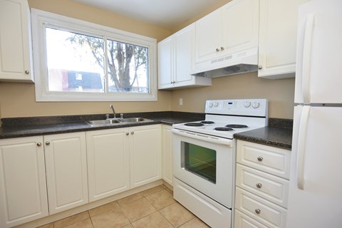 a kitchen with white appliances and black counter tops and white cabinets