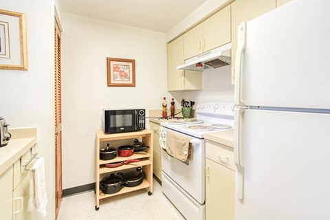 a kitchen with white appliances and a refrigerator