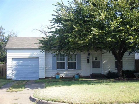 a white house with a tree in front of it