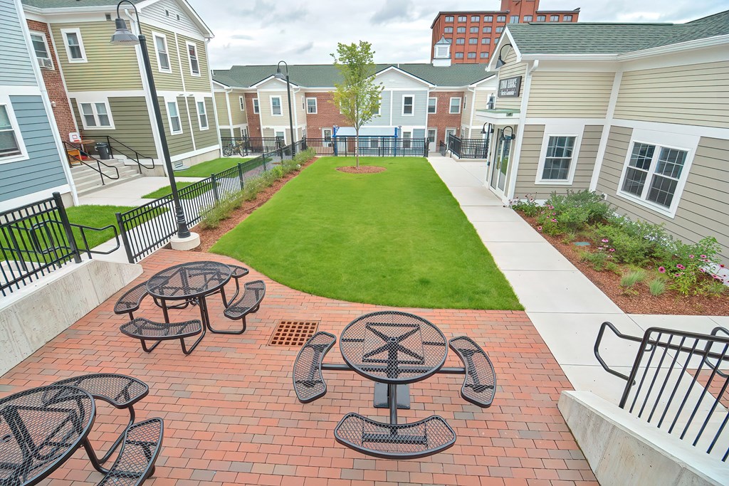 an aerial view of a yard with tables and chairs in front of houses