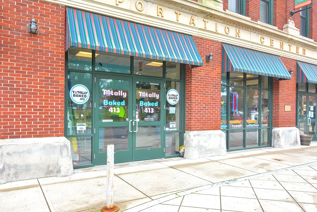 a store front of a brick building with green doors