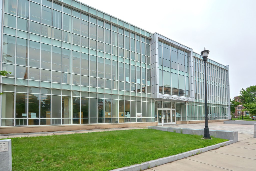 a large glass building with a lawn in front of it