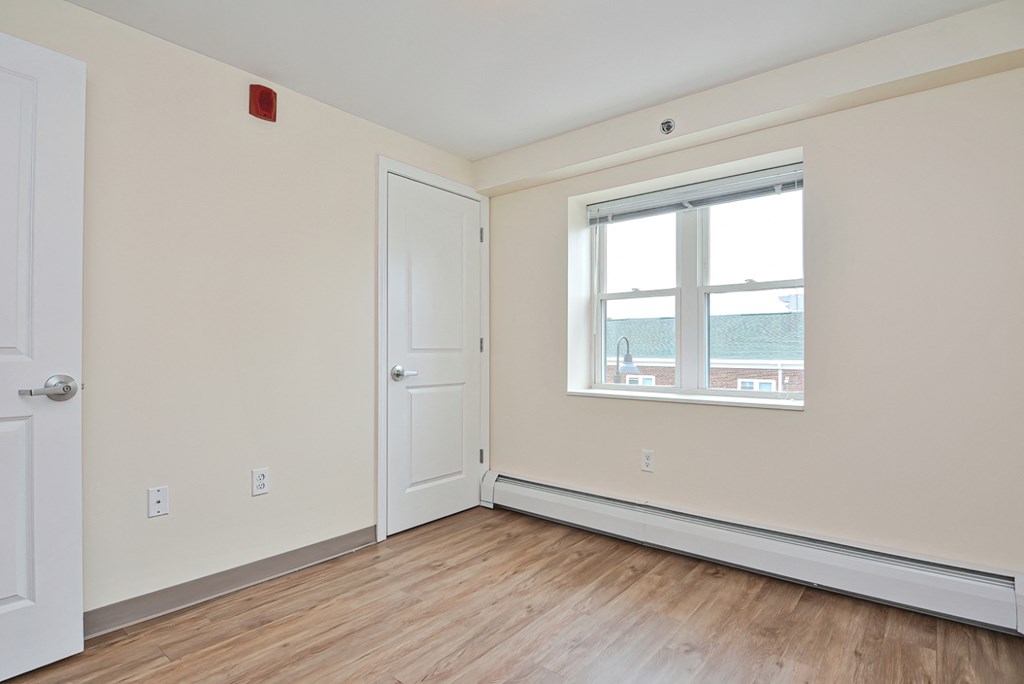 an empty room with white walls and a window