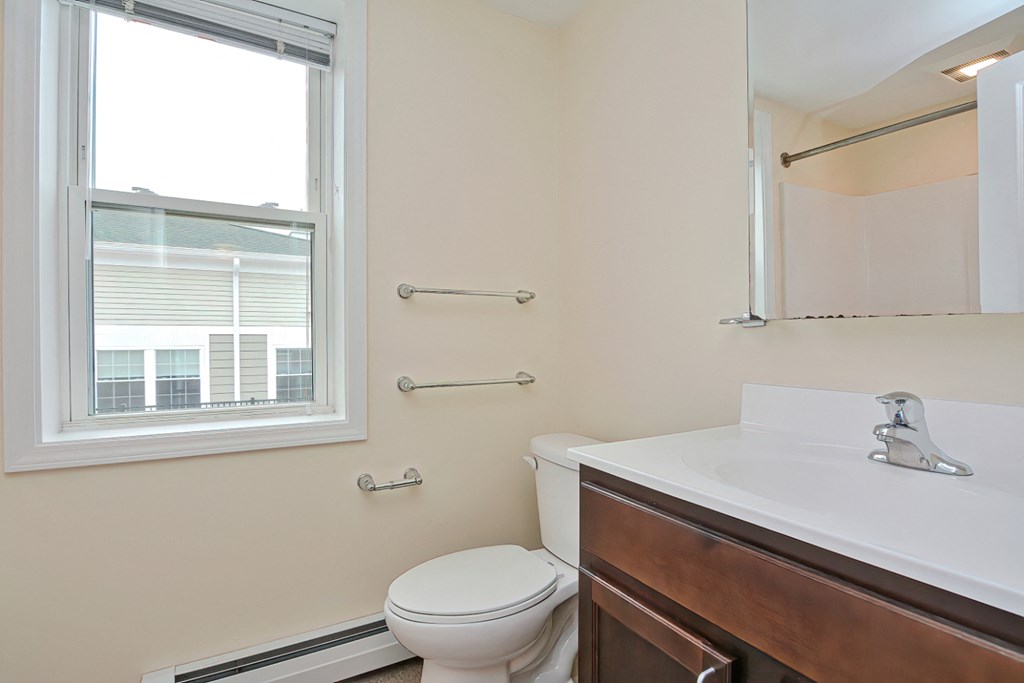 a bathroom with a toilet and a sink and a window