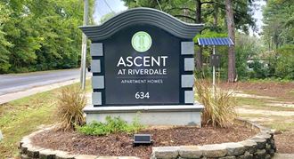 a sign for the assent at riverdale apartments on the side of a road