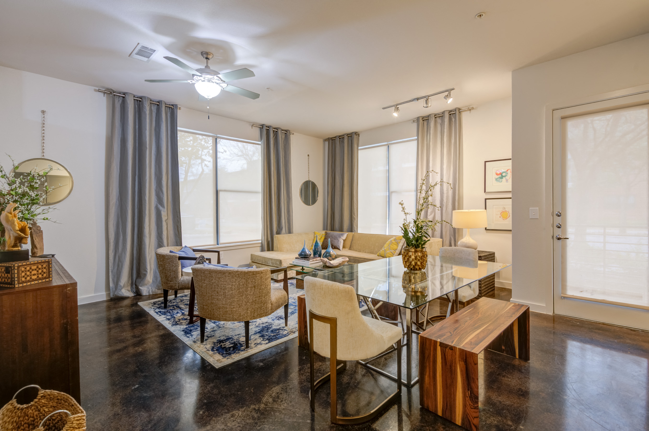 a living room with a dining room table and chairs and a ceiling fan