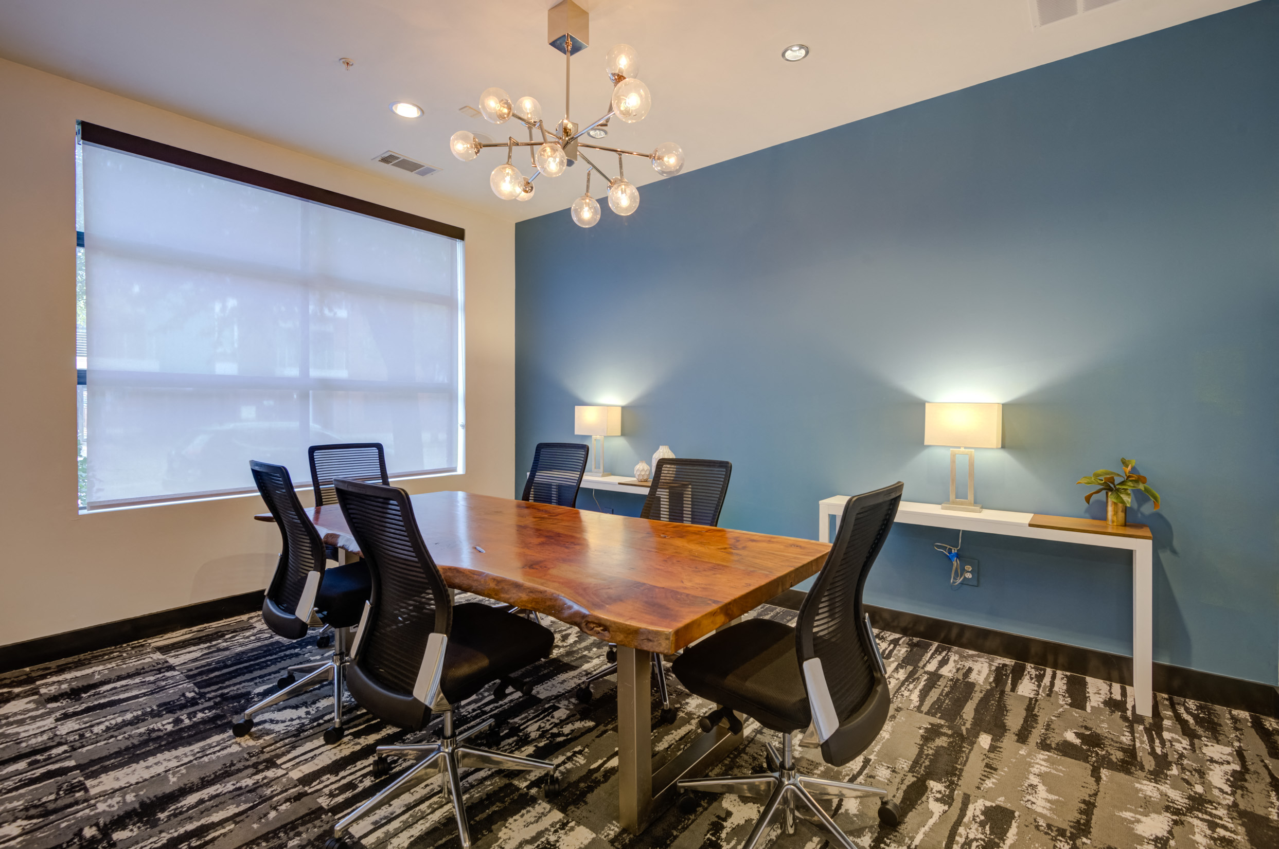 a conference room with a table and chairs and a chandelier
