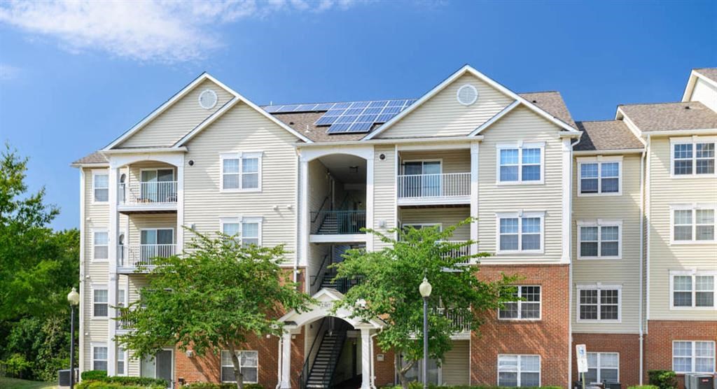 an apartment building with solar panels on the roof