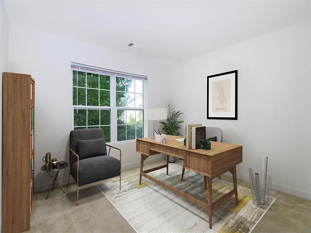 a living room with a desk and a window