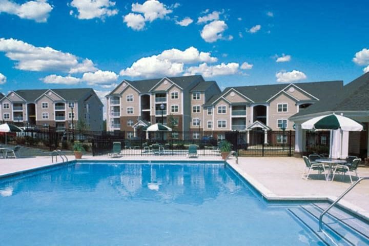 a large swimming pool with apartments in the background