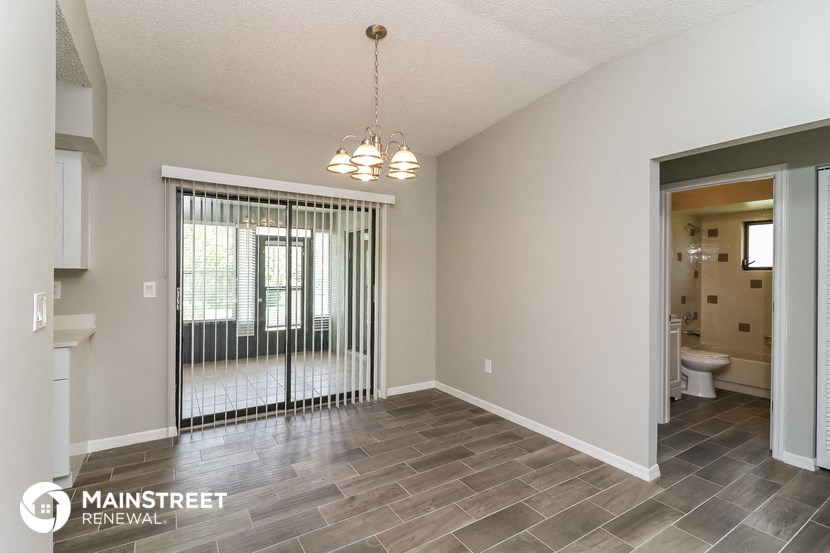 an empty living room with a sliding glass door to the bathroom