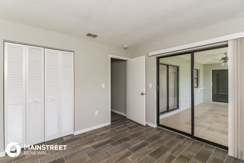 the living room of an apartment with sliding glass doors to the hallway