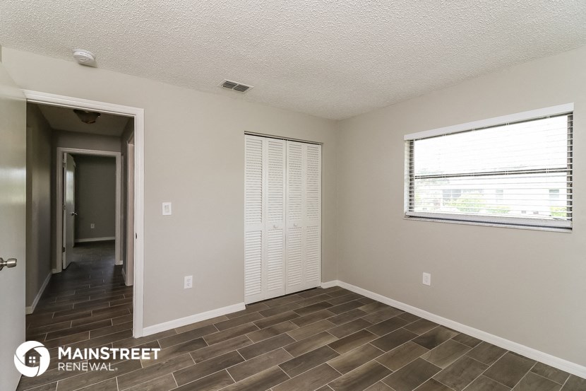 a living room with a door to a hallway and a window