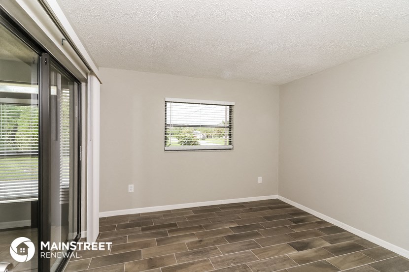 the living room of a house with a window and a door