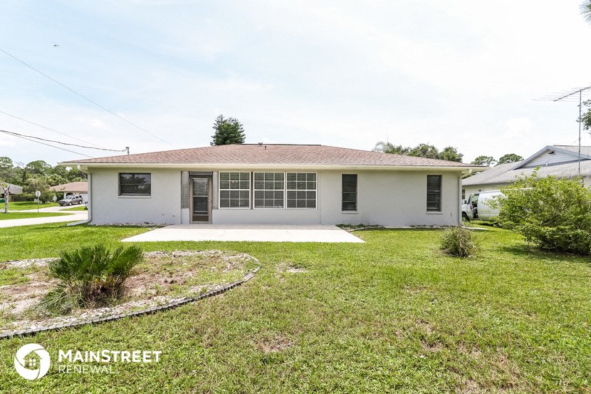 a small white house with a yard and grass
