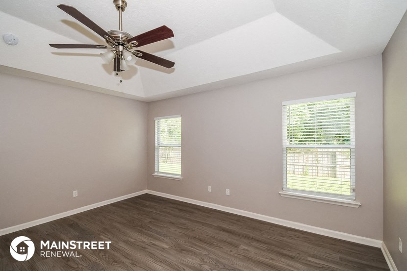 the interior of an empty room with a ceiling fan