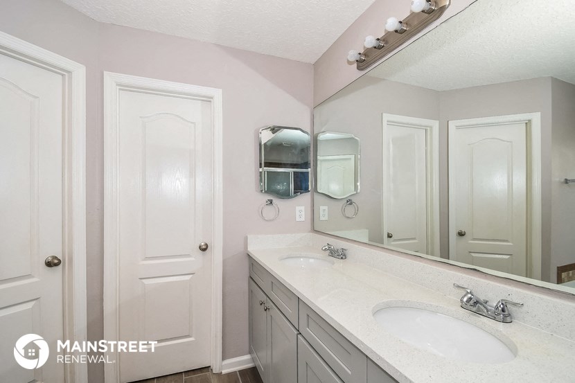 a bathroom with two sinks and a large mirror