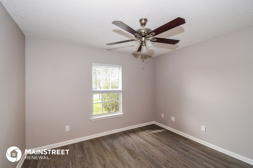 the interior of a bedroom with a ceiling fan and a window
