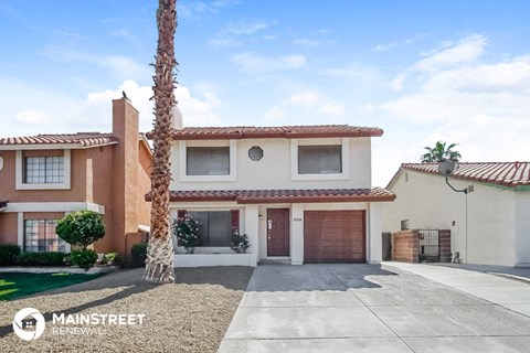 a house with a sidewalk and a palm tree in front of it
