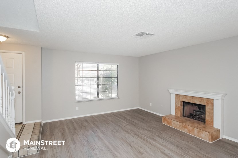 a living room with a fireplace and a wooden floor