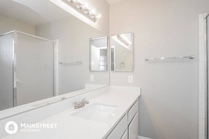 a bathroom with a sink and a mirror and a shower
